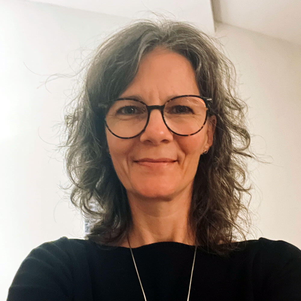 Porträt von Katrin Strabel vor neutralem Hintergrund. Das Bild zeigt sie als achtsame Energiecoachin und Wegbegleiterin, die Vertrauen, Nähe und Klarheit ausstrahlt.