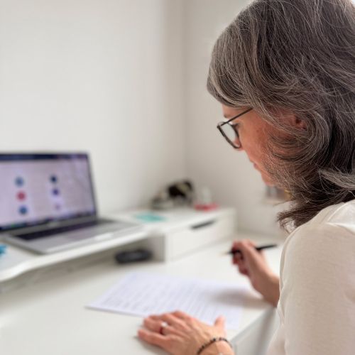 Frau mit weitschwingendem Rock tanzt fröhlich, lebendig und bewusst im Einklang mit sich selbst im Wald zwischen den Bäumen als Symbol für Wachstum, innere Freiheit und Muttersein gepaart mit Persönlichkeitsentwicklung .