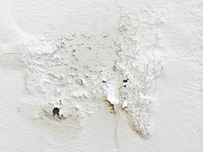 Flurecke mit Türrahmen, Fußleiste und einem dunklen Wasserfleck an der Wand