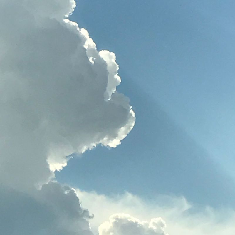Wolken auf der linken Seite, blauer Himmel rechts, Sonnenlicht strahlt durch – Symbol für Klarheit, Verständnis und Mitgefühl in Beziehungen
