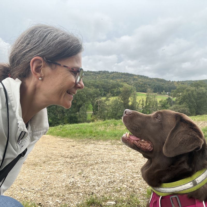 Katrin Strabel und Labrador Fina auf einer Wiese – herzliche Verbindung und gegenseitiges Vertrauen